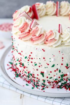 a white frosted cake with red and green sprinkles