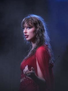 a woman in a red dress standing on stage