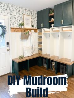 an organized mud room with green cabinets and white linens on the shelves, along with baskets