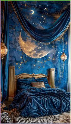 a bedroom decorated in blue with gold stars and crescents hanging from the ceiling above it