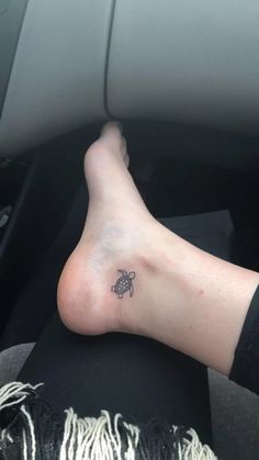 a person's foot with a small turtle tattoo on the left side of their leg