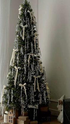 a decorated christmas tree with white lights and bows