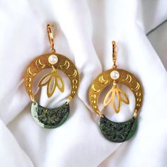 The floral crescent moons are handcrafted from polymer clay in light to deep, dark green accented with multichrome color shifting pigment. Attached to a crescent moon phase piece with a faux pearl accent and a cute floral charm dangling from the center. Gold plated Lever backs. Measures: 6.6x3cm Handmade Green Crescent Jewelry, Whimsigoth Jewelry, Dreamy Jewelry, Moon Nature, Brass Jewellery, Gifts For Friend, Earrings Moon, Gift For Sister, Celestial Jewelry