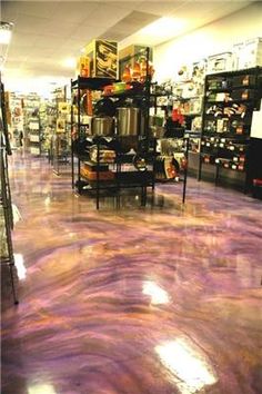 the floor is covered in purple dye and has shelves full of items on it,