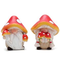 two gnome figurines sitting next to each other on a white surface with red and yellow mushrooms growing out of them