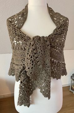 a crocheted shawl on a mannequin