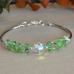 Made with 4mm crystals, 8mm clear swarovski crystal and silver bars Swarovski Crystal Jewelry Diy, Beautiful Beaded Earring, Peridot Crystal, Beaded Earring, Bracelets Design, Swarovski Crystal Jewelry, The Bangles, Beaded Jewelry Tutorials, Crystal Bangle