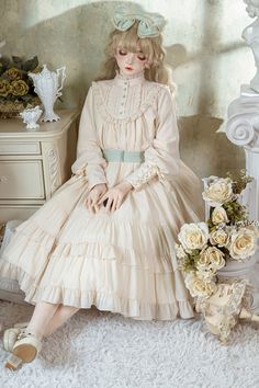 A relaxed and elegant silhouette. A classic dress with gorgeous frills on the chest and lace-up decoration on the cuffs. The large collar gives an impression of purity and elegance. She tied a ribbon around her waist, making her look like a gorgeous aristocratic lady. 
 
 

 

 
 
 Item 
 
 Long length 
 Middle length 
 
 
  Image of length by item  
 Long length 
 
 Middle length 
 
 
 Types of waist ribbon 
 
 Wide (3 rows) 
 Standard (2 rows) 
 
 
 Size 
 
 
 Long length 
 
 S size 
 
 Length Regency Style Cream Dress With Ruffles, Elegant Beige Victorian Dress With Ruffles, Cream Long Sleeve Midi Dress With Lace Trim, Cream Long Sleeve Dress With Lace Collar, Feminine Dress With Ruffles And Bishop Sleeves, Feminine Ruffled Dress With Bishop Sleeves, Feminine Ruffle Dress With Bishop Sleeves, Feminine Long Sleeve Dress With Lace Collar, Regency Victorian Dress With Ruffles In Cream