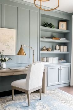 a home office with blue walls and white furniture, including a gold chandelier