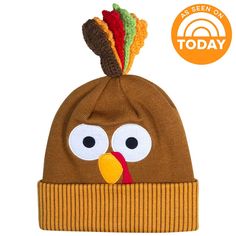 a brown hat with a turkey face on it's side and a multi colored pom - pom attached to the top