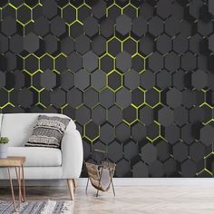 a white couch sitting in front of a wall covered in black and yellow hexagonal tiles