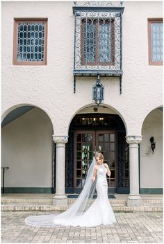 a woman in a wedding dress is posing for the camera with her veil blowing in the wind