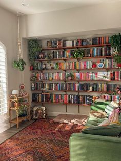 a living room filled with furniture and lots of books on the shelves in front of it