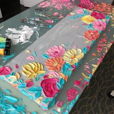 the table is decorated with flowers and acrylic paint on it's surface