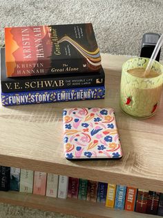 a table topped with books and a cup of coffee next to a stack of books