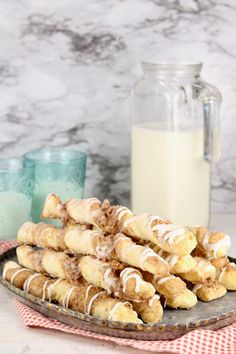 a plate full of cinnamon rolls next to a glass of milk