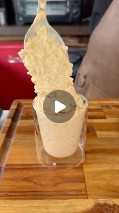 an ice cream sundae is being served on a wooden tray with a bottle in the background