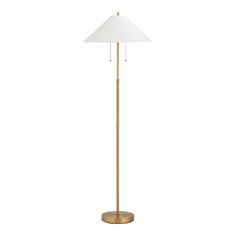 a floor lamp with a white shade on the top and a gold base, in front of a white background