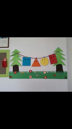 a bulletin board with clothes hanging from it's sides and trees on the other side