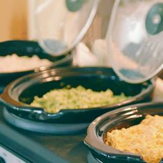 two black bowls filled with food on top of a stove