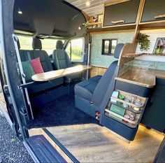 the interior of an rv with blue carpeting and wooden tables in the back area