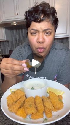 a man making a face while holding a plate with fried food in front of him