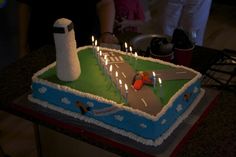 a birthday cake with candles in the shape of a road and traffic signal on it