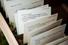 there are many different types of business cards in the box with moss growing on them