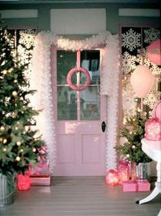 christmas trees and presents in front of a pink door