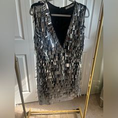 a dress made out of metal strips hanging on a door