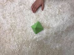 someone is laying on the floor with an origami piece in front of them