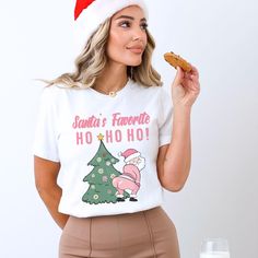 Dive into the festive spirit with our Pink Santa's Favorite Ho Ho Ho t-shirt, perfect for spreading holiday cheer in style. This Christmas shirt is not just another Santa shirt; it's a fun and quirky addition to your seasonal wardrobe. Ideal for Christmas parties or casual wear, this funny Christmas tee is a playful nod to Santa's favorite catchphrase. The design of this holiday shirt featuring 'Ho Ho Ho' in a whimsical font is sure to bring smiles wherever you go. Embrace the joy of the season with this favorite ho shirt, radiating merriment with every 'Ho' displayed proudly. Make a statement and celebrate the holidays with this Ho Ho Ho shirt that captures the essence of Christmas in a light-hearted and amusing way. Bella and Canvas This classic unisex jersey short sleeve tee fits like a Holiday White Pre-shrunk T-shirt, Fun White T-shirt For Holiday, Fun Christmas Holiday T-shirt, Santas Favorite Ho, Santa Tee, Christmas Party Shirt, Whimsical Fonts, Seasonal Wardrobe, Christmas Party Shirts