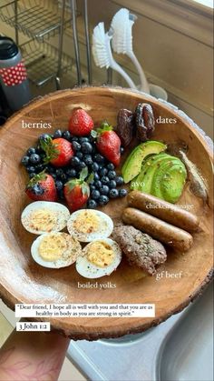 a wooden bowl filled with different types of fruits and veggies on top of it