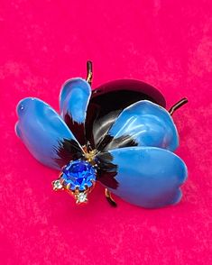 This is a beautiful vintage Hattie Carnegie blue enameled winged bug brooch; the large black body and legs contract beautifully with the robin blue wings and sapphire blue prong-set set head and pale blue eyes. Beautiful example of vintage Hattie Carnegie. Hattie Carnegie - born Henrietta Kanengeiser on March 15, 1889 in Vienna, Austria, Hattie Carnegie became a legendary American jewelry and fashion designer in the 1920s-1950s. Vintage Blue Cabochon Jewelry, Hattie Carnegie Brooch, Antique Handmade Blue Brooches, Pale Blue Eyes, Robin Blue, Elegant Blue Butterfly Brooches, Handmade Vintage Butterfly Brooch, Black Body, Blue Wings