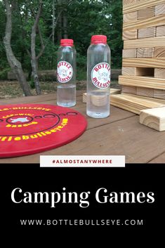 two water bottles sitting on top of a wooden table next to a red frisbee