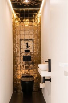 a black and white bathroom with gold foil covering the walls