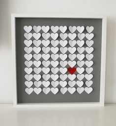 a white frame with hearts cut out of it and a red heart in the middle