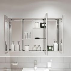 a white bathroom sink sitting under a mirror next to a shelf filled with bottles and containers