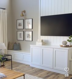 a flat screen tv mounted to the side of a white wall in a living room