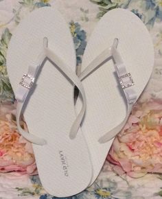 Flip flops, wedding flip flops, for guests, bride flip flops, bridal flip flops, wedding party flip flops, beach wedding, gift for bride A pair of white or black Old Navy flip flops adorned with a two inch grosgrain ribbon rhinestone buckled bow. Petite bow is approximately 2 inches in length. All ribbons are heat sealed. Bottom of bow is sewn to flip flop for durability. These are fun flirty and fabulous!! They look good with everything!! Perfect for a bride after the ceremony who wants to rela White Summer Flip Flops As Gift, White Flip Flops As Summer Gift, White Summer Flip Flops For Party, White Summer Party Flip Flops, Elegant Gift Flip Flops, Elegant Adjustable Flip Flops For Beach, Elegant Beach Flip Flops, Wedding Flip Flops For Guests, Bride Flip Flops