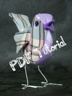 a small bird made out of fabric with a purple bow on it's head