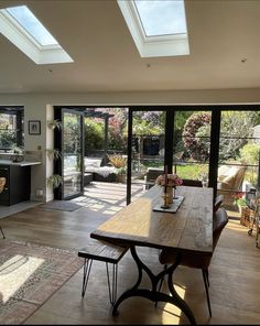 an open kitchen and dining room with skylights on the ceiling, windows to outside