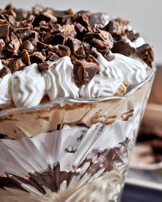 a dessert with chocolate and whipped cream in a glass dish on top of a table