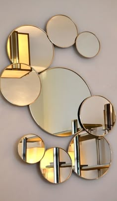 several mirrors are arranged on the wall with one light in front of them and another behind it