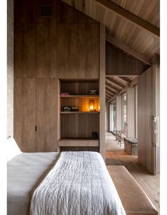 a bedroom with wood paneling and built - in bookshelves on the wall