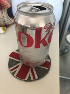 a soda can sitting on top of a coaster with the word ok painted on it