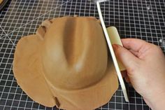 a person is making a hat out of clay