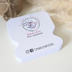 a white business card sitting on top of a table next to a stuffed animal and some burlocks