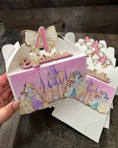 someone is holding up some princess themed birthday cards and envelopes with the number 4 on them