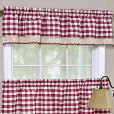 red and white checkered kitchen curtains hanging on the wall next to a table with a lamp